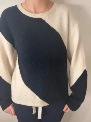 Stickad tröja med svartvitt mönster - Säljer en  stickad tröja i mjukt material med breda svarta och vita blockmönster. Tröjan har rund halsringning och långa ärmar. Perfekt för dig som gillar en avslappnad och trendig stil. I storlek 170 men sitter som en xs-s