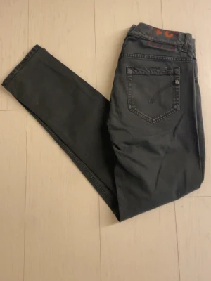 Dondups  - Säljer ett par svarta jeans från dondup med klassisk femficksdesign och raka ben. Jeansen har diskreta sömmar och dondup logan på bakfickan. Perfekta för dig som gillar en enkel och stilren look. Materialet känns mjukt och följsamt.