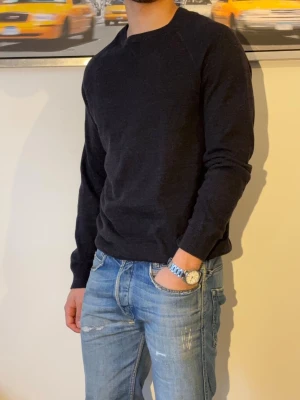 Stickad crewneck - En stilren mörkblå stickad tröja med rund hals och långa ärmar. Tröjan har en enkel design utan synliga loggor eller mönster och är tillverkad i ett mjukt material som passar perfekt till jeans. Ribbstickade muddar vid ärmslut och nederkant.