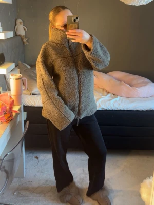 Grå teddyjacka med dragkedja - Mysig grå teddyjacka från Gina tricot med hög krage och hel dragkedja framtill. Jackan har en avslappnad passform och är tillverkad i fluffigt teddy-material som håller dig varm. Perfekt för kyliga dagar och enkel att styla till olika outfits. Den har fickor!! Man kan även ha kragen nedvikt!!