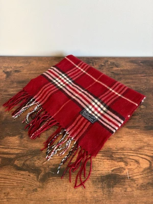 Burberry Halsdsuk - Vintage Burberrys halsduk i 100% lambswool. Made in England. Klassisk check i mörkare/bruna toner med diskret och tidlös look. Väldigt bra skick med endast mindre tecken på användning. Perfekt för en clean casual/old money stil.