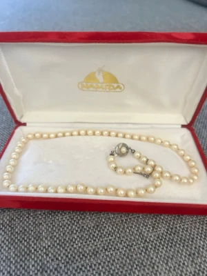 NAMIDA klassiskt pärlhalsband - I fint skick för sin ålder. Äkta silver i låset. Silver 835. Pärlorna är dock inte äkta. Asken medföljer. 