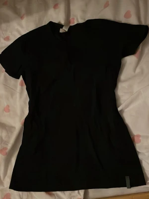 Svart basic t-shirt - En klassisk svart t-shirt med rund hals och korta ärmar. Perfekt att matcha med jeans eller kjol för en enkel och stilren look. T-shirten har en normal passform och är tillverkad i mjukt bomullstyg. Alltid att ha en hel svart T-shirt hemma, bara ifall:) 