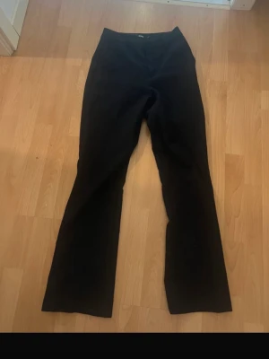 Svarta kostymbyxor från Bik Bok - Snygga svarta kostymbyxor från Bik Bok med klassisk rak passform och diskreta fickor. Perfekta för en stilren look. Byxorna har hällor för skärp och är tillverkade i ett mjukt tyg som ger en bekväm känsla hela dagen.