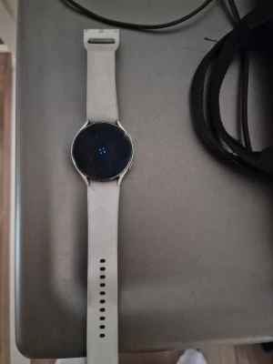 Samsung Galaxy Watch4 vit smartklocka - Snygg Samsung Galaxy Watch4 med vit silikonrem och rund svart urtavla. Klockan har en stilren design i metall och passar perfekt för dig som vill ha koll på träning, hälsa och notiser direkt på handleden. Använd 5 gånger köpte i december 2025