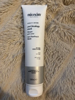 Nioxin anti-breakage hårmask 150 ml - Nioxin Density Defend anti-breakage mask är en intensivt vårdande hårmask som motverkar håravbrott. Kommer i en vit och silver tub på 150 ml. Perfekt för dig som vill stärka och skydda håret.