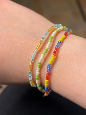 Handgjorda armband  - Handgjorda armband.  Bestäm 2 eller flera valfria färger.  5kr skänks till Barncancerfonden för varje sålt armband🎗️   3 för 85kr  Färger som går att välja mellan: - röd/rosa - rosa (3 olika varianter) - blå (3olika varianter) - ljusblå - grön - mörkgrön - lila - gul - peach  - guld - brun - vit - svart - grå