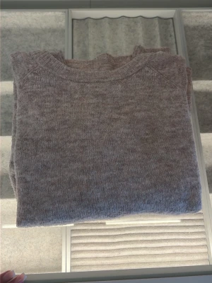 Beige/rosa stickad tröja från 157 - Mysig beige stickad tröja från 157 med rund halsringning och ribbade muddar. Perfekt för lager-på-lager och enkel att matcha med jeans eller kjol. Tröjan har en klassisk och avslappnad passform.