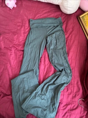 Gröna utsvängda leggings Gina Tricot - Snygga gröna leggings från Gina Tricot med utsvängda ben och låg midja då man kan vika hur lågt man vill. Mjukt och stretchigt material som sitter skönt. Perfekta för en chill och trendig look.