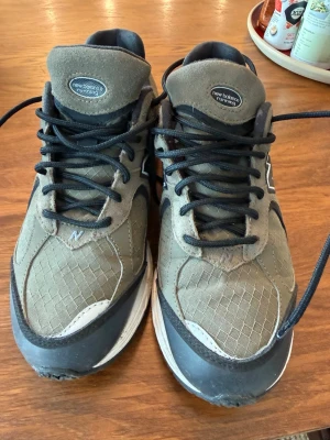 New Balance 2002R olivgröna sneakers - Säljer ett par New Balance 2002R sneakers/vandrig/löpning olivgrönt med svarta och vita detaljer. Skorna har mesh och mocka i ovandelen, svart N-logga på sidan och svart snörning. Skorna är vattentäta i Gore-Tex. Mellansulan är vit med svart och grå yttersula. Perfekta för långa promenader i alla väder.