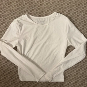 Vit långärmad topp från SHEIN - Säljer en enkel och fräsch vit långärmad topp från SHEIN. Modellen är klassisk med rund hals och normal passform, perfekt att styla med jeans eller kjol. Materialet är mjukt och skönt bomull som känns bekvämt mot huden. En basic topp som funkar till många olika looks