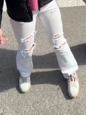 Vita ripped jeans - Säljer ett par vita jeans med utsvängda och flera slitningar på framsidan. Jeans. Perfekta för en cool och avslappnad stil.