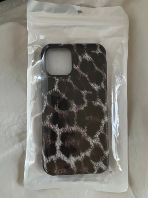 Mobilskal leopardmönster brun/svart - Snyggt mobilskal med leopardmönster i bruna och svarta toner. För iPhone 11 Pro. Tillverkat i tåligt plastmaterial och ger mobilen en trendig look. Helt oanvändt. 