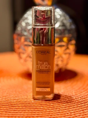 L'Oréal True Match Foundation - L'Oréal Paris True Match Super-Blendable Foundation i en varm brun nyans. Kommer i en glasflaska med pump och silverfärgat lock. Innehåller hyaluronsyra för återfuktning och ger en naturlig finish. Passar dig som vill ha en foundation som smälter in i huden. 60% är kvar i flaskan. För mängd se även bild. 