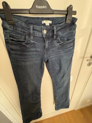 Mörkblå jeans från Gina tricot - Snygga mörkblå jeans från Gina tricot med klassisk femficksdesign och raka ben. Jeansen har normal midja och är tillverkade i stretchigt denimtyg för extra komfort. Perfekta för en avslappnad och trendig look.