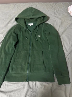 Lacoste tracksuit grön  - Använd men fortfarande i bra skick inga fel på den alls säljer då jag vuxit ur den, storleken är xs i herr storlek. Priset är ej hugget i sten så tveka inte på att skriva 