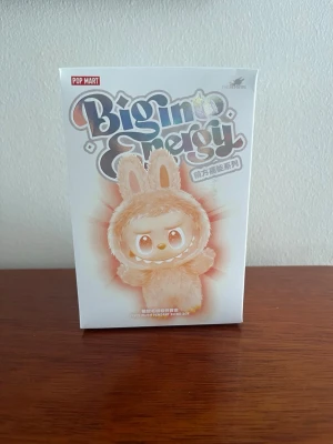 Pop Mart Big Energy samlarfigur - Säljer en Pop Mart Big Energy samlarfigur i originalförpackning. Boxen har en söt figur med kaninöron i beige och vitt, och är tillverkad av plast. Perfekt för dig som gillar unika samlarprylar eller vill ha något gulligt till hyllan.