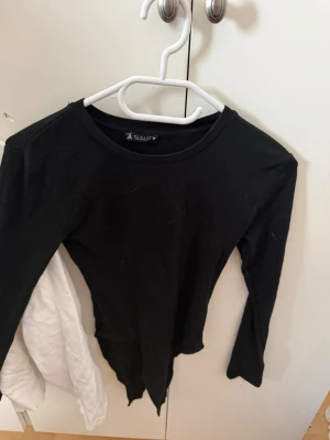 Svart långärmad body från Zara - En stilren svart långärmad body från Zara i mjuk bomull. Enkel och klassisk design med rund halsringning, perfekt att matcha med olika outfits. Snygg och bekväm för dig som gillar minimalistisk stil.