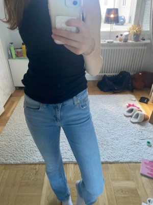 Ljusblå bootcut jeans - Säljer ett par ljusblå bootcut jeans med klassisk femficksdesign och låg/medel midja. Jeansen har en snygg utsvängd passform nertill och är perfekta för en avslappnad men trendig look. Materialet är denim i bomull. Köpta på Lager 157 men tycker de är lite korta då de är i längden ”short”, är 168cm