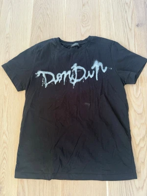 Svart t-shirt från Dondup - Cool svart t-shirt från Dondup med vit spraymålad logga framtill. Klassisk rund halsringning och korta ärmar. Köpt på United Fashion i Göteborg. Storlek: M | Skick: 8,5/10 (bara damm på bilderna) Meddela vid eventuella frågor! Allt gott!