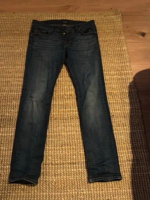Mörkblå skinny jeans Jack & Jones - Säljer ett par mörkblå skinny jeans från Jack & Jones storlek 31/30. Jeansen har knappgylf och kontrastsömmar. Perfekta för dig som gillar en smal passform och tidlös stil.