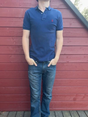 Ralph Lauren piké  - Snygg mörkblå piké från Ralph Lauren i bra skick, pikén är i storlek S och är perfekt till sommaren! Tveka inte på att skriva vid frågor eller funderingar! Modellen är ca 180cm och väger ca 73 kg