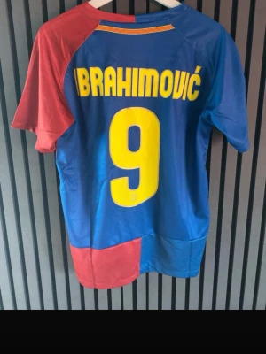 Barcelona Ibrahimović matchtröja - Säljer en klassisk FC Barcelona matchtröja från Nike med Ibrahimović och nummer 9 på ryggen. Tröjan är blå och röd med gula detaljer, officiellt klubbmärke och Unicef-logga på bröstet. Perfekt för dig som älskar fotboll och vill ha en ikonisk supportertröja.