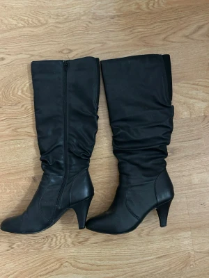 Svarta höga stövlar med klack - Snygga svarta stövlar med hög klack och slouchy skaft. Dragkedja på insidan för enkel påtagning. Klassisk och stilren design som passar till många outfits. Tillverkade i ett matt material som ger en modern look.💗💗