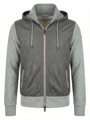 Grå vindjacka från Moncler med huva - Snygg grå vindjacka från Moncler med huva och dragkedja framtill. Jackan har mjuka ärmar och muddar i ljusgrått tyg, samt två fickor med dragkedja. Moncler-logga på vänster ärm och justerbar dragsko i huvan.