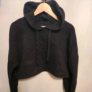 Hoodie Gina Tricot S - hoodie från Gina Tricot S  Svart croppad hoodie från Gina Tricot med huva och snörning. Tröjan har långa ärmar och ribbade muddar. Perfekt för en chill och avslappnad stil. Mjuk och skör bomullsblandning.  Kan även hämtas I Partille  E1
