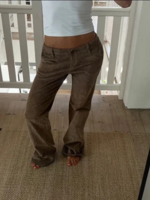 Bruna utsvängda manchesterbyxor - Snygga bruna manchesterbyxor med utsvängda ben och klassisk passform. Byxorna har normal midja och stängs med knapp och dragkedja. Köpta secondhand, i bra skick. Skulle säga passar 34/36