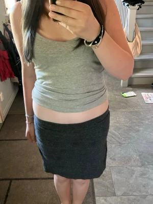 Mörkgrå enkel kortkjol - Säljer en mörkgrå, enkel och stilren kortkjol i mjukt material. Kjolen har en rak passform och är perfekt för dig som gillar en clean och basic look. Passar till många olika outfits och är superbekväm att bära.