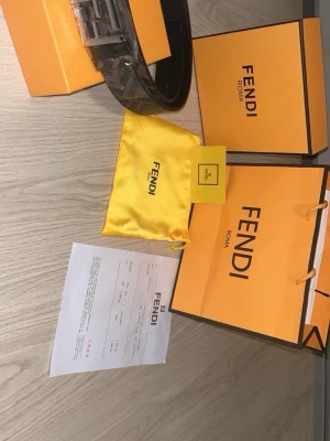 Svart Fendi bälte med FF-spänne - Snyggt svart bälte från Fendi med det ikoniska FF-spännet i metall. Bältet har en stilren design och levereras med originalförpackning, dustbag och kvitto. Perfekt accessoar för att lyfta din outfit.