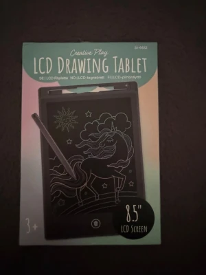 LCD Drawing Tablet  - LCD Drawing Tablet med 8,5 tums skärm och medföljande penna. Perfekt för att rita, skriva eller göra anteckningar digitalt. Tabletten är svart och har en smidig, tunn design. Drivs av utbytbart CR2025-batteri och är enkel att använda för både kreativitet och planering.