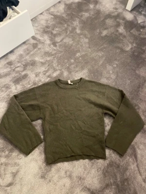 Olivgrön stickad tröja - En enkel och stilren olivgrön som går in lite i midjan. Storlek S. Från Nelly, aldrig använd