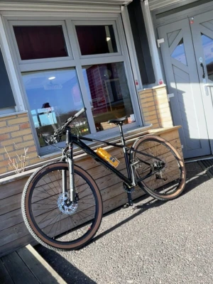 Svart mountainbike med bruna däck - Säljer en stilren svart mountainbike med mattsvart ram och bruna däck. Cykeln har raka styren, skivbromsar och en vattenflaska hållare. Perfekt för både stad och terräng. Snygg och modern design som sticker ut. Bromsarna funkar perfekt utan problem. Luft suspension. Priset kan diskuteras 