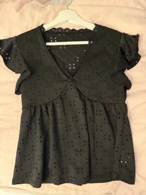 Svart blus med volang - Svart blus med v-ringning och volangärmar. Storlek xs/s 