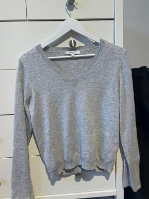 Tunn grå långärmad - Köpt här på Plick och har klippt bort en volang som satt längst ner på tröjan, se bild. Använd ett fåtal gånger och säljer vidare då den inte faller mig i smaken. 