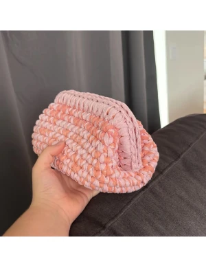 Rosa/orange necessär  - Söt handgjord necessär i virkad design med mjukt garn i ljusrosa och persikofärgade toner. Perfekt för smink eller småprylar. Metallramen gör väskan enkel att stänga och öppna. Virkad i återvunnet material. 