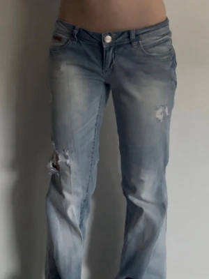 Ljusblå slitna jeans - Fina jeans med slitna detaljer! Storlek: w29 L34 mått: midjemått rakt över ca 40 cm, Innerbenslängd ca 82 cm (kolla våran TikTok för mer videos/ bilder på jeansen)