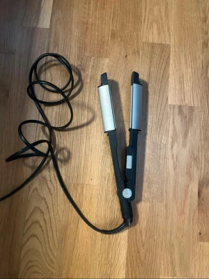 BaByliss plattång - Säljer en plattång/ locktång i svart och silver med rundade värmeplattor värms up till 230~  och sladd. Perfekt för att fixa snygga lockar eller rakt i håret. Enkel att använda.