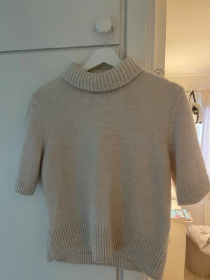 Beige stickad tröja med polokrage från hm - Stickad beige t shirt med polo krage, populär o slutsåld från HM. Storlek L men är absolut lite mindre i storleken. Inga defekter alls använd minimalt.