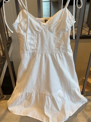 Sommarklänning med volang, H&M - Somrig vit klänning från H&M, perfekt till student alt midsommar, super elegant, volang nertill & tunna knytbara axelband, med prislapp kvar helt ny. 🤍
