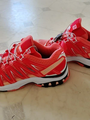 Röda Salomon XA Pro 3D V9 sneakers - Snygga Salomon XA Pro 3D V9 sneakers i rött med vita och svarta detaljer. Skorna har mesh-ovandel för bra ventilation, snabbsnörning och robust sula för extra grepp. Perfekta för en aktiv livsstil och streetwear. Skorna är i toppskick, Endast använda några enstaka gånger. Nypris runt 1400-1900:-
