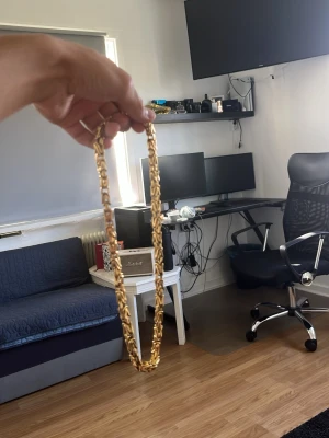 Guldigt kedjehalsband - Snyggt halsband i guldfärgad metall med kraftig kedja och rektangulära länkar. Halsbandet har en modern och stilren design som passar perfekt till olika outfits. Inget synligt märke på halsbandet. Köpt på indossa. 8mm
