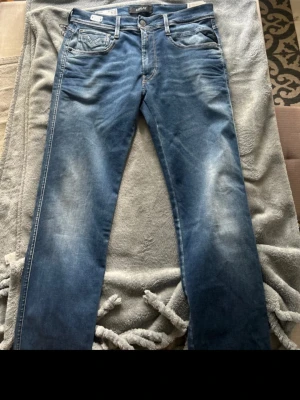 Blå Replay Hyperflex jeans herr - tjena säljer dessa Super trendiga blåa Replay jeans från Replay i modellen Hyperflex med klassisk femficksdesign och lätt slitna detaljer. Jeansen har raka ben och normal midja, tillverkade i stretchigt denim för extra komfort. Perfekta för en avslappnad och trendig look. Modell Anbass Jeans i nyskick aldrig Använda. Storlek: W 31 L 32  Säljer pågrund av att dom inte kommit till användning✨ Nypris Ca 1,700kr Mit pris 1000kr  Priset är inte hugget i sten, Kom med ett bra Prisförslag🤝