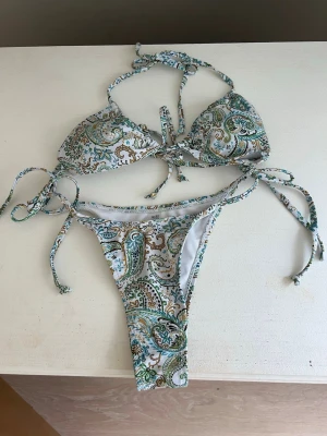 7 paisleymönstrade bikinis - Säljer 7 trendiga bikinis med paisleymönster, en i blått och vitt och en i grönt, brunt och vitt. Alla har trekants-bh med knyt i nacke och rygg samt matchande trosa med knyt i sidorna. Perfekta för stranden eller poolen!