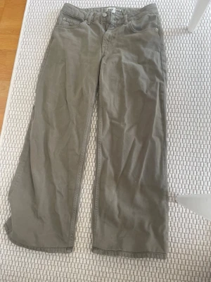 Gröna jeans med raka ben - Snygga gröna jeans med klassisk femficksdesign och raka ben. Byxorna har hällor för bälte och stängs med knapp och dragkedja. 