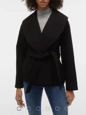 Svart kappa - Stilren svart kappa med bred krage och knytskärp i midjan. Kappan har en rak passform och är tillverkad i ett mjukt tyg som ger en snygg siluett. Perfekt för dig som gillar minimalistisk och modern stil.