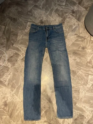 Blå raka jeans från Gant - Klassiska blå jeans från Gant med rak passform och fem fickor. Jeansen har en snygg tvättad look. Tillverkade i slitstarkt denimtyg, perfekta för en avslappnad stil.
